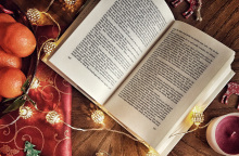 Ανοιχτό βιβλίο πάνω σε χριστουγεννιάτικα στολισμένο τραπέζι