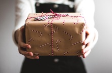 Μια κοπέλα κρατάει ένα δώρο.