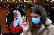 Κοπέλα με μάσκα για κορωνοϊό σε χριστουγεννιάτικη αγορά στο Λονδίνο