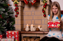 Ένα κορίτσι κρατάει στα χέρια του το χριστουγεννιάτικο δώρο του