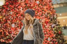 Ξανθιά κοπέλα μπροστά από το χριστουγεννιάτικο δέντρο