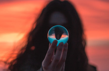 Κοπέλα κρατάει γυάλινη μπάλα με αντανάκλαση του εαυτού της