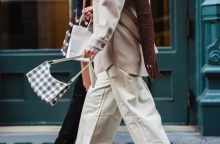 Γυναίκες προχωρούν στο δρόμο κρατώντας τσάντα και σακούλες από ψώνια