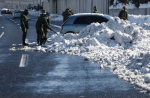 Στην Αττική Οδό στρατιώτες απομακρύνουν χιόνια από αυτοκίνητο