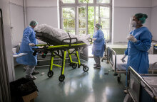 Υγειονομικοί σε νοσοκομείο μεταφέρουν φορείο για ασθενείς με κορωνοϊό