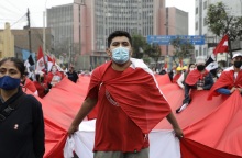 Διαδηλωτής στο Περού με κόκκινη μπλούζα και μάσκα προστασίας