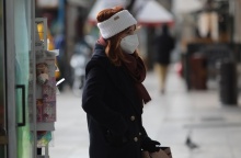 Κρύο - Πτώση θερμοκρασίας - Γυναίκα με σκούφο περπατά στο δρόμο