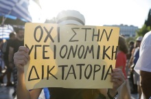Γυναίκα που κρατά πλακάτ σε συγκέντρωση αντιεμβολιαστών