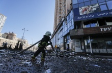Πυροσβέστης στο Κίεβο κρατά μάνικα πατώντας σε συντρίμμια από βομβαρδισμούς