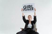 Γυναίκα σε καρέκλα που κρατά πινακίδα με τη φράση "Girl Power"
