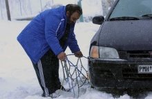 Οδηγός τοποθετεί αντιολισθητικές αλυσίδες στο όχημά του