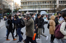 Πολίτες με μάσκα προστασίας από τον κορωνοϊό περπατούν στο κέντρο της Αθήνας