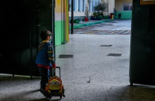 Μικρός μαθητής με την τσάντα του περιμένει να μπει στην τάξη του