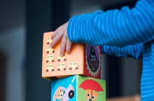 Χέρια παιδιού σε παιχνίδι με κύβους