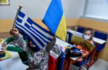 Παιδιά- πρόσφυγες από την Ουκρανία κρατούν την ελληνική και την ουκρανική σημαία σε χώρο όπου μαθαίνουν ελληνικά στο κέντρο της Αθήνας