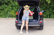 Φωτογραφία μίας γυναίκας να τοποθετεί τα πράγματά της στο πόρτμπαγκάζ.