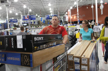 Καταναλωτές σε κατάστημα με γεμάτα καρότσια