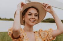 Νεαρή κοπέλα που φοράει καπέλο και χαμογελάει