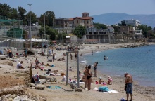 Λουόμενοι σε παραλία απολαμβάνουν την ηλιοθεραπεία τους - Ζέστη στην Αττική τον Μάιο του 2022