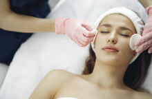 Γυναίκα ξαπλωμένη με κλειστά μάτια, δέχεται καθαρισμό προσώπου