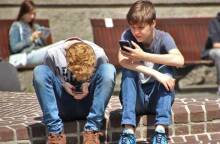 Δύο αγόρια που ασχολούνται με τα κινητά τους