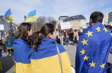 Δύο γυναίκες με τη σημαία της Ουκρανίας κι άντρας με τη σημαία της Ευρωπαϊκής Ένωσης σε πορεία