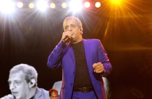 Ο Θέμης Αδαμαντίδης τραγουδά στη σκηνή και κρατά το μικρόφωνο