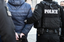 Άνδρας με χειροπέδες οδηγείται στο δικαστήριο συνοδευόμενος από αστυνομικούς