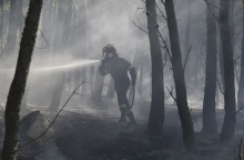 Πυροσβέστης πίσω από καπνούς από την πυρκαγιά