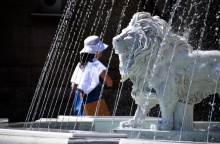 Λιοντάρι σε σιντριβάνι και γυναίκα με καπέλο προστατεύεται από τον καύσωνα