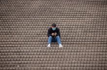 Πολίτης με μάσκα προστασίας από τον κορωνοϊό κάθεται σε σκαλιά