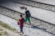 Μετανάστες περπατούν δίπλα στις γραμμές τρένου