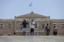 Τουρίστες ποζάρουν στον φωτογραφικό φακό μπροστά από τη Βουλή