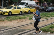 Γυναίκα με ομπρέλα περπατά σε δρόμο