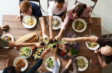 Παρέα τσουγκρίζει ποτήρια σε τραπέζι φαγητού