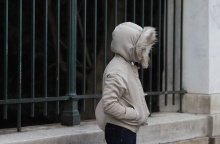 Γυναίκα προστατεύεται από το κρύο φορώντας μπουφάν και κουκούλα