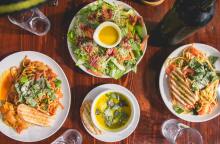 Γεύμα με σαλάτα, κρασί και δύο πιάτα στο τραπέζι