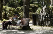 Συνταξιούχος διαβάζει την εφημερίδα του καθισμένος σε παγκάκι