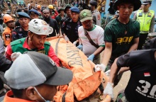 Σωστικά συνεργεία μεταφέρουν πτώμα από τον φονικό σεισμό στην Ινδονησία