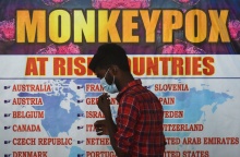 Άνδρας μπροστά από παλαιότερο κατάλογο με χώρες όπου υπήρχε κίνδυνος μετάδοσης της ευλογιάς των πιθήκων