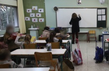 Δασκάλα μπροστά από τον πίνακα διδάσκει σε μαθητές δημοτικού