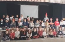 Μαθητές με χριστουγεννιάτικα καπέλα τραγουδούν το ένα δίπλα στο άλλο