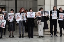 Συγγενείς θυμάτων της πύρινης τραγωδίας στο Μάτι κρατούν φωτογραφίες των νεκρών έξω από το δικαστήριο