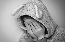 Ανήλικη κρύβει με τα χέρια το πρόσωπό της, ενώ με κουκούλα κρύβει το κεφάλι της