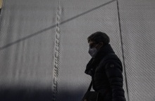 Γυναίκα περπατά φορώντας τη μάσκα προστασίας κατά του κορωνοϊού