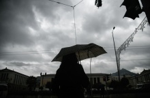 Γυναίκα με ομπρέλα προστατεύεται από την καλοκαιρινή βροχή