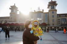 Γυναίκα με μωρό φορούν μάσκα προστασίας από τον κορωνοϊό σε πόλη της Κίνας