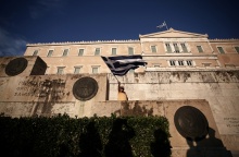 Άνδρας κυματίζει την ελληνική σημαία έξω από τη Βουλή των Ελλήνων