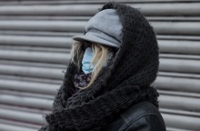 Γυναίκα με μάσκα προστασίας από τον κορωνοϊό, κουκούλα και κασκόλ