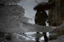 Η σκιά ατόμου με ομπρέλα σε λιμνάζοντα νερά